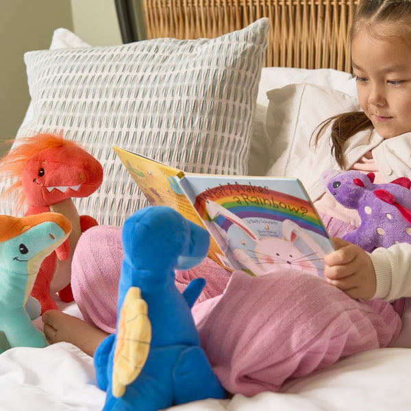 Child reading to stuffed animal dinos